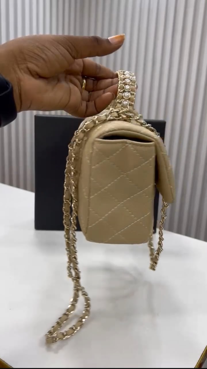 Sac Chanel matelassé beige avec chaîne dorée, vue de côté